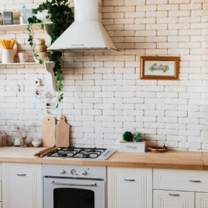 Stylish kitchen interior with modern appliances, wooden counters, and greenery accents.