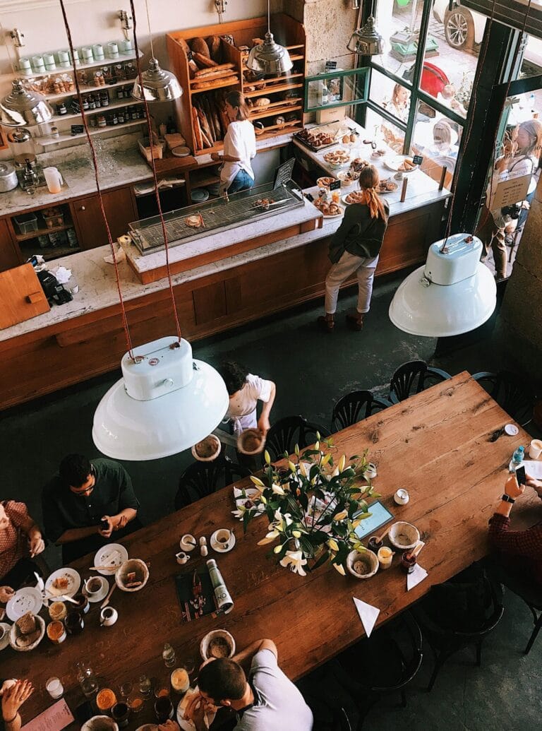 A vibrant aerial view of a busy cafe in Kraków, showcasing patrons enjoying baked goods and coffee.